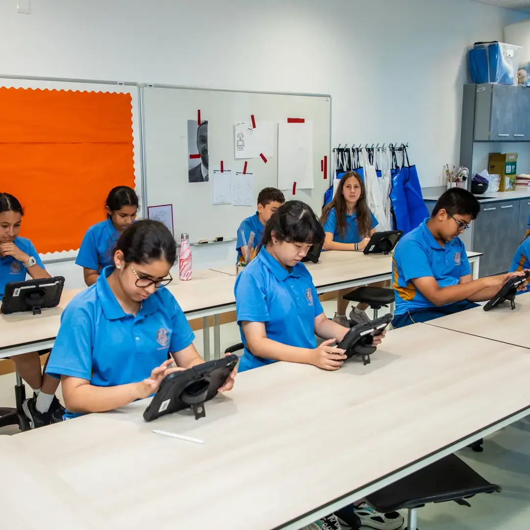 Sherborne School Jeddah students completing classwork on electronic tablets.