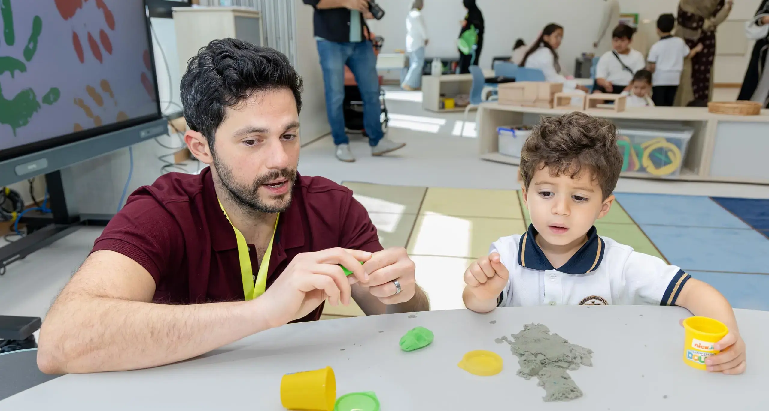 Sherborne Jeddah student and teacher building with playdough and sand.