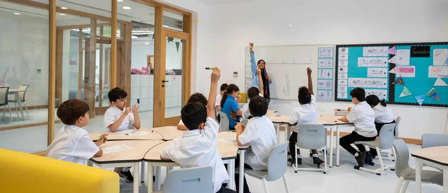 Sherborne School Jeddah students with hands raised in a lesson.