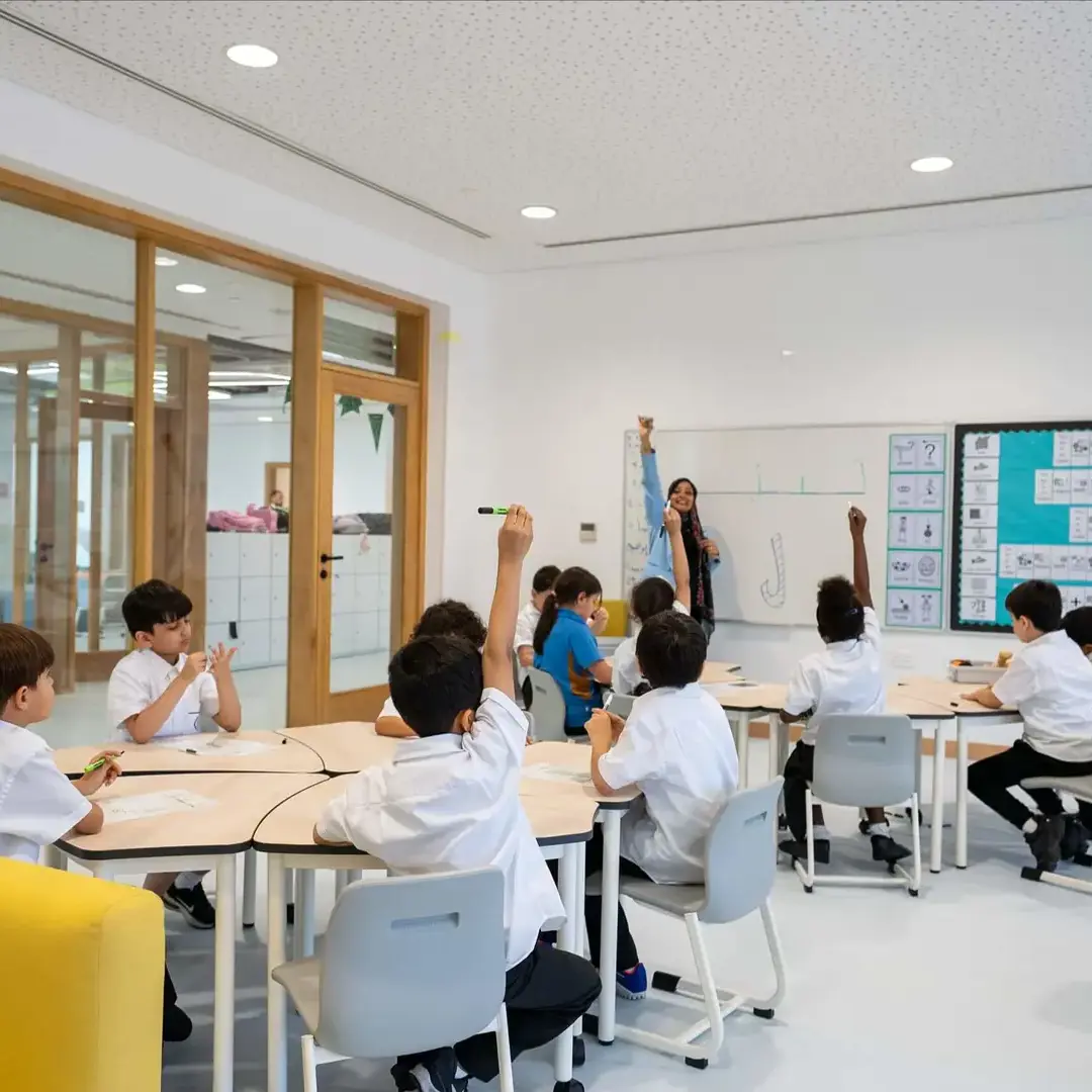 Sherborne School Jeddah students with their hands up in a lesson.