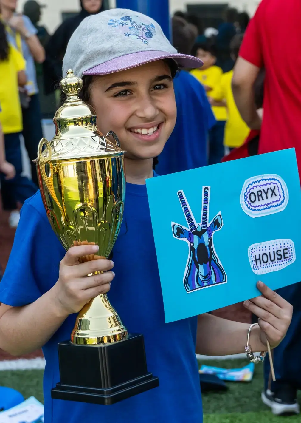 Sherborne School Jeddah student holding a trophy on sports day.
