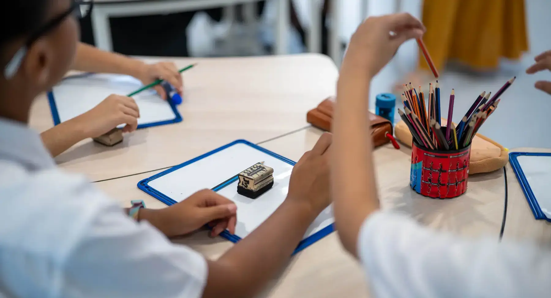 Sherborne School Jeddah students using pencils to write in a lesson.
