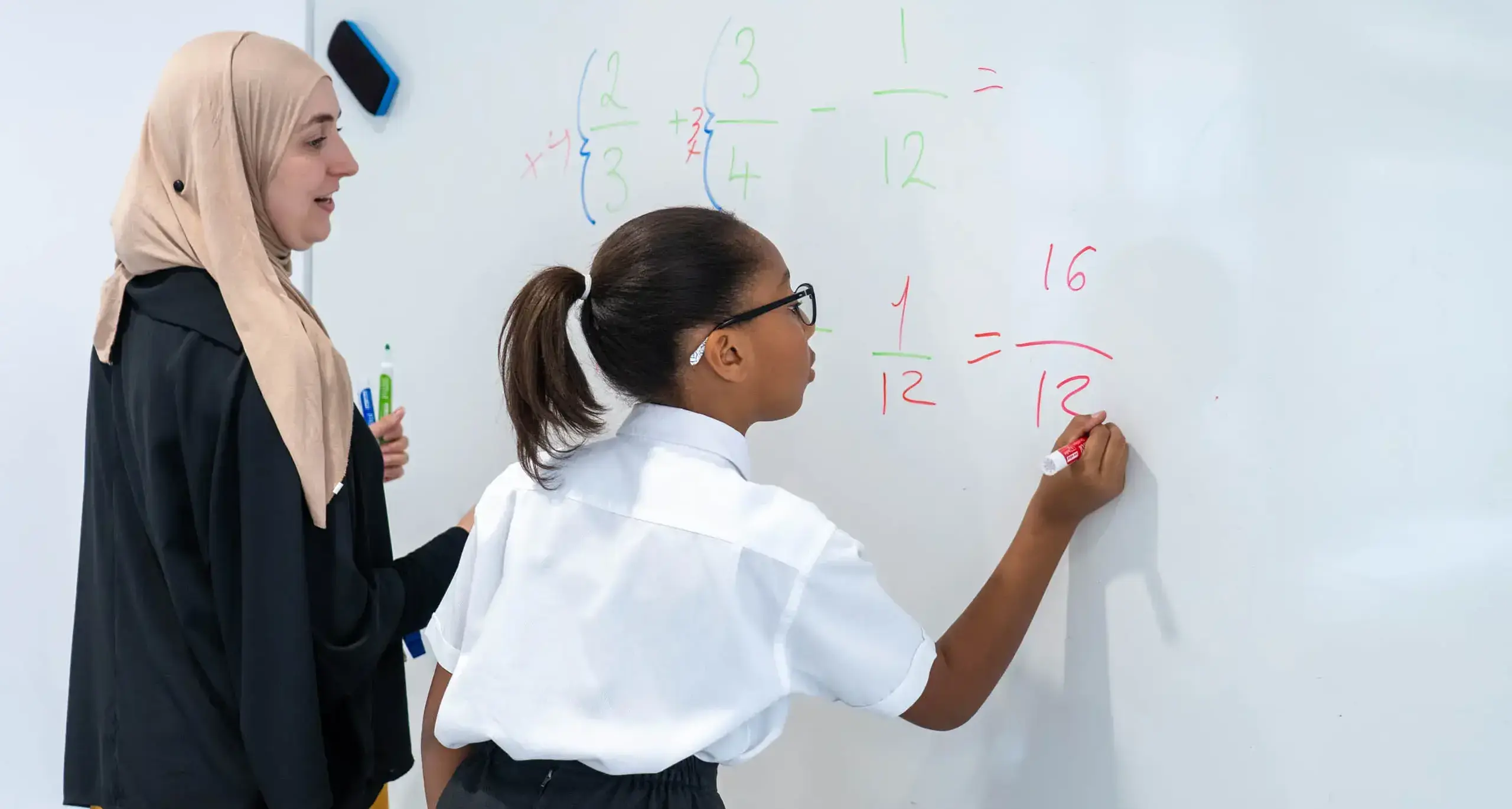 Sherborne School Jeddah student writing on a whiteboard during a maths lesson.