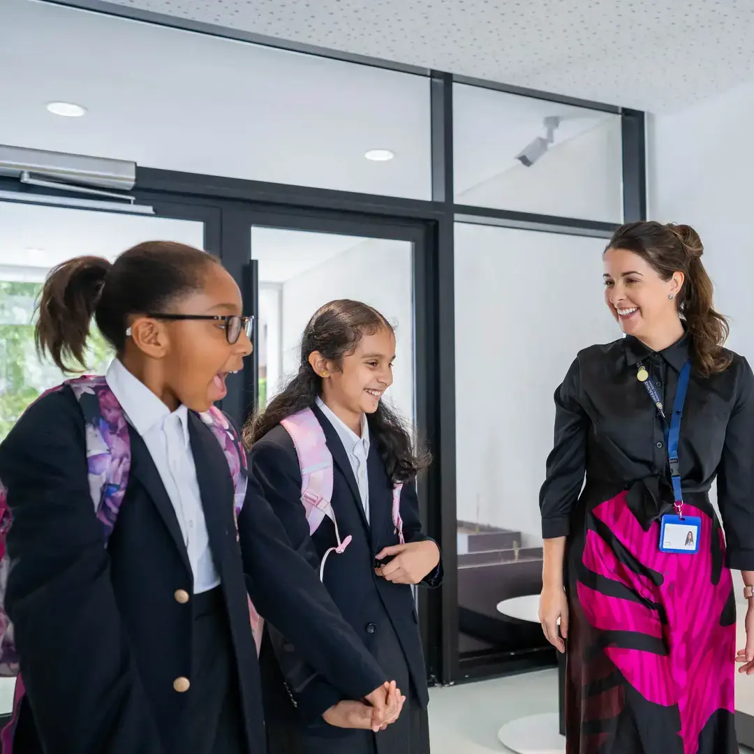 Sherborne School Jeddah teacher and students chatting in a hallway.