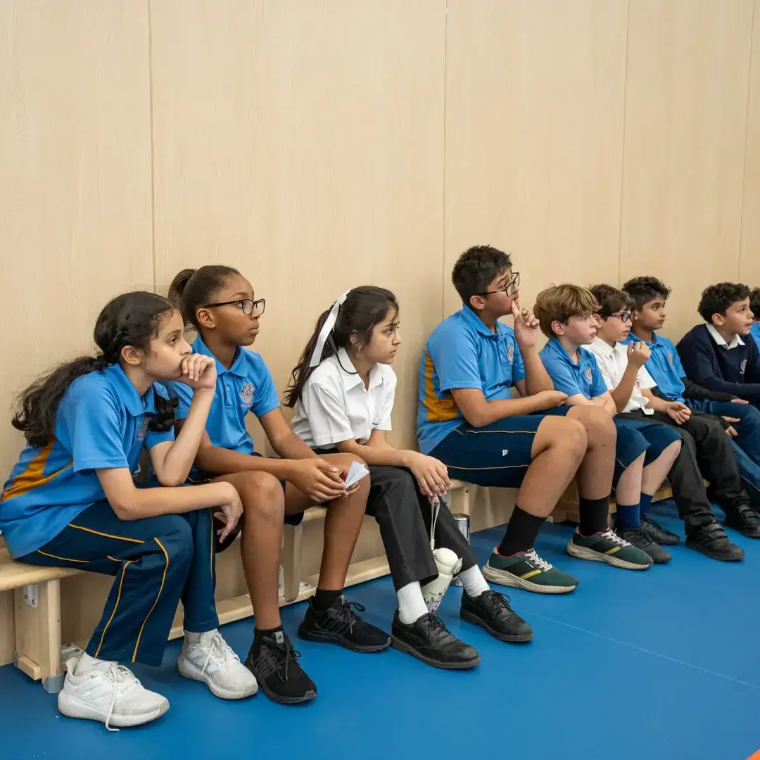 Sherborne School Jeddah students sitting on a bench in a sports lesson.