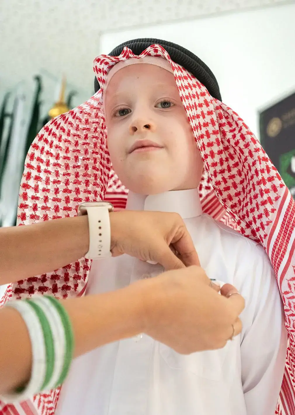 Student wearing traditional clothing smiles for a photograph.
